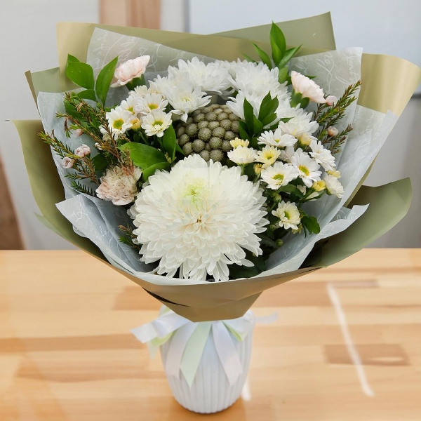 Magnum White Chrysanthemum - 1, Baltica White Spray Chrysanthemum - 1, Carnation white, cream - 3, Santini White Spray Chrysanthemum - 2, Brunia Green Lanuginosa (1 pc.), Waxflower (1 pc.), Ruscus, Wrapping Paper, Ribbon