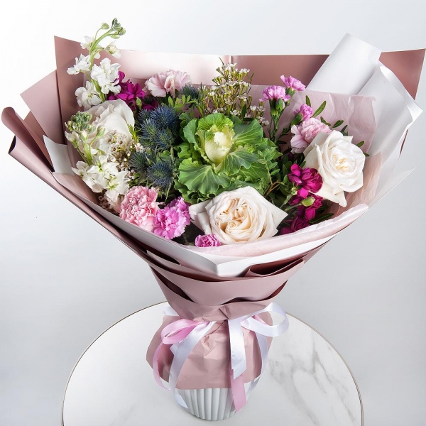 Peony style roses - 3, White Matthiola - 2, Pink spray carnation - 4, Pink carnation - 3, Waxflower (1 pc.), Eryngium, Pistachio, Wrapping Paper, Brassica
