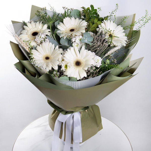 Гербера белая - 9, Маттиола белая - 3, Фисташка, Эвкалипт, Бруния, Эрингиум, Грин белл, Сухоцветы в ассортименте, Современная упаковка